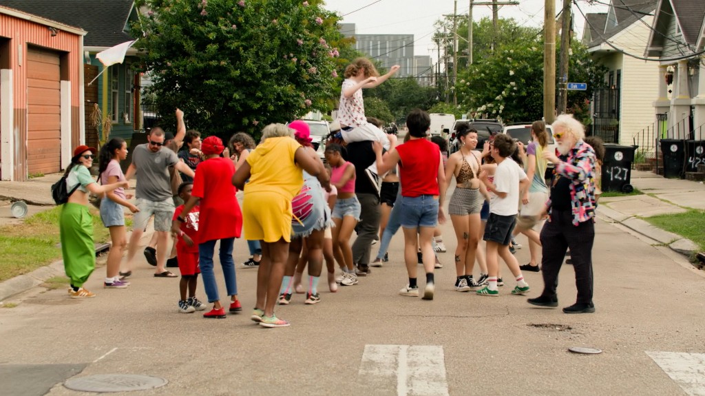 Neighbors dancing together in the middle of a residential street
