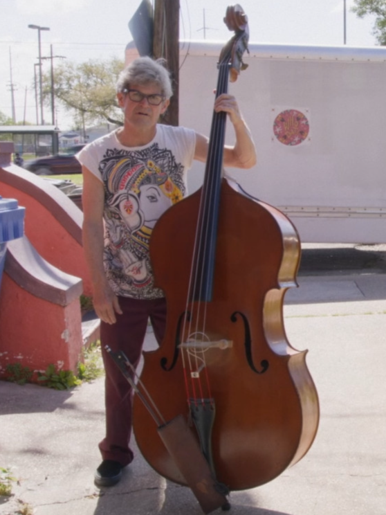 Musician holding a double bass outdoors