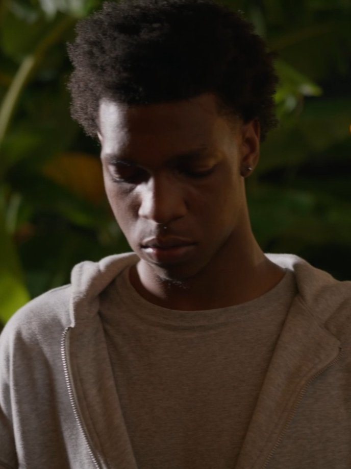 Close portrait of a young man under leafy night foliage