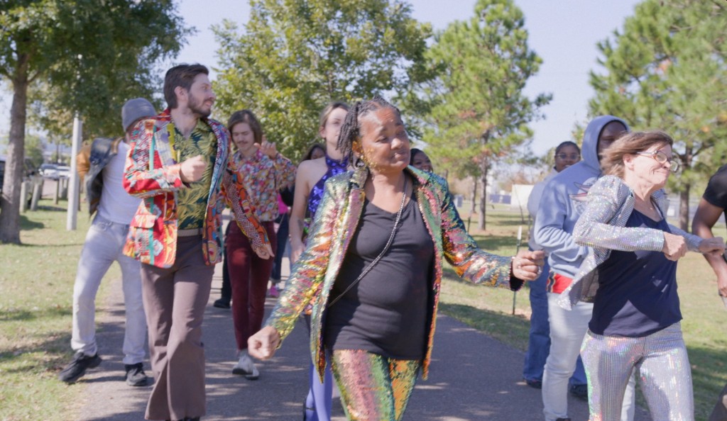 Neighbors dancing outdoors in bright sequined costumes
